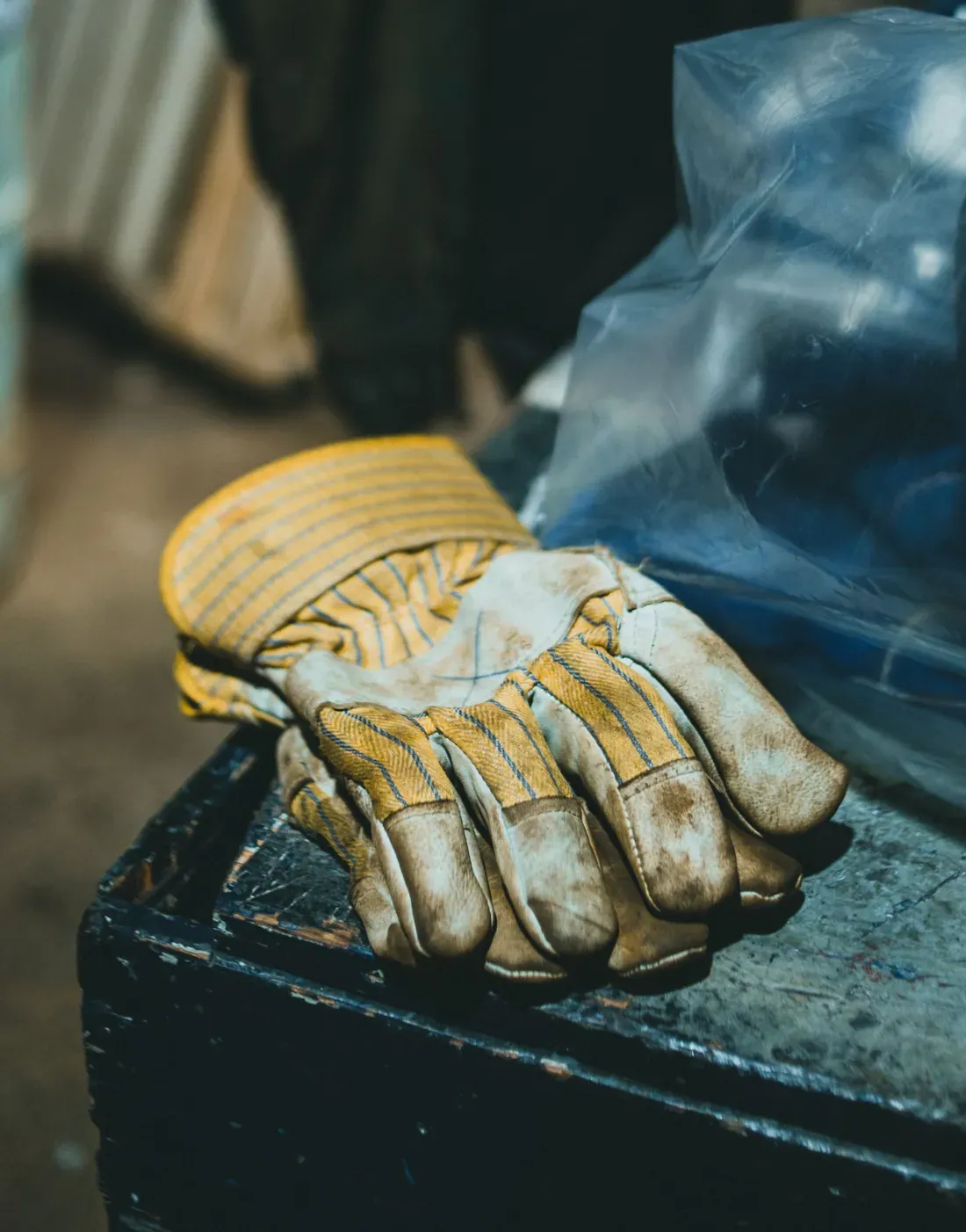 Leather work gloves resting on an industrial machine